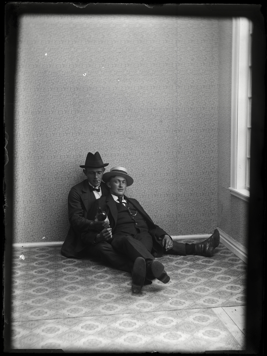 Två män sittande på golvet