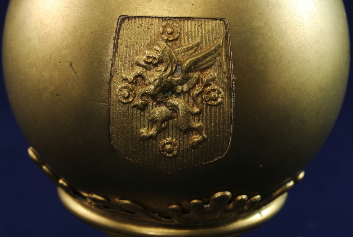 Sparbössa i mässing i en svärisk form på en dekorerad fot och krönt av en krona. Myntinkast finns i kronan och lucka med nyckelhål på botten. På framsidan finns Östergötlands vapensköld. På baksidan är ingraverat "Östergötlands Enskilda Bank, Hemsparbössa". 
På botten finns serienummer 2153.
Nyckel saknas.