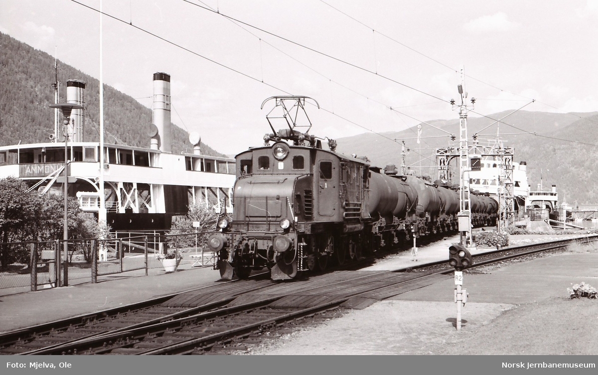 Rjukanbanens elektriske lokomotiv nr. 14, tidligere NSB El 1 2001, med godstog til Rjukan på Mæl stasjon. Til høyre DF Ammonia, bak til høyre MF Storegut og MF Rjukanfoss