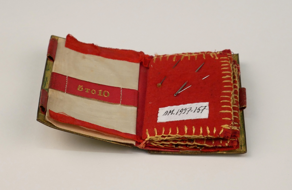 Nålbrev i form av en liten bok. Grönt omslag med röda sidor av filt. Har tillhört Alingsås museums grundare Anna Norlander.