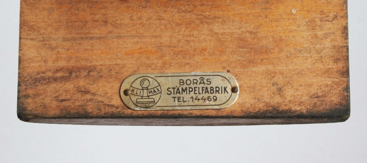 Sköldformad, svart gummistämpel, märkt: "BORÅS Wiskania, A-B. N.H. LJUNGBERGS LÄDERFABRIK". Under denna, avlång stämpel märkt: "EXTRA".
Båda fästa på konkav, brunbetsad träplatta med greppvänligt handtag.

Historik: 
N.H Ljungberg startade år 1903 en läderaffär på Allégatan i Borås och företaget utvidgades och kom även omfatta partiförsäljning av skodon och galoscher. År 1916 startade Ljungberg läderfabriken vid Gässlösavägen. Fabrikens produktion bestod till en början huvudsakligen av bottenläder men utökades senare till att även innefatta diverse ovanläder och sulläder. Under 1940-talet bildades ett antal dotterbolag till företaget för tillverkning av skor och tofflor. Vid den här tiden fanns det 75 anställda vid fabriken i Borås. Samtliga bolag som var knutna till fabriken samlades senare under företagsnamnet Wiskaniabolagen. År 1969 ingick AB Ljungbergs läderfabrik, AB Ljungbergia, Sko AB Wiskania samt försäljningsbolaget Wiskania AB i bolaget. År 1972 blev Wiskania Sko AB löntagarägt, av drygt 100 anställda gick 92 personer in och blev delägare i bolaget. Verksamheten vid Wiskania Sko AB lades ner under 1991.

En storsäljare ända in i nutid, var skor i allmogestil till folkdans och dylikt.