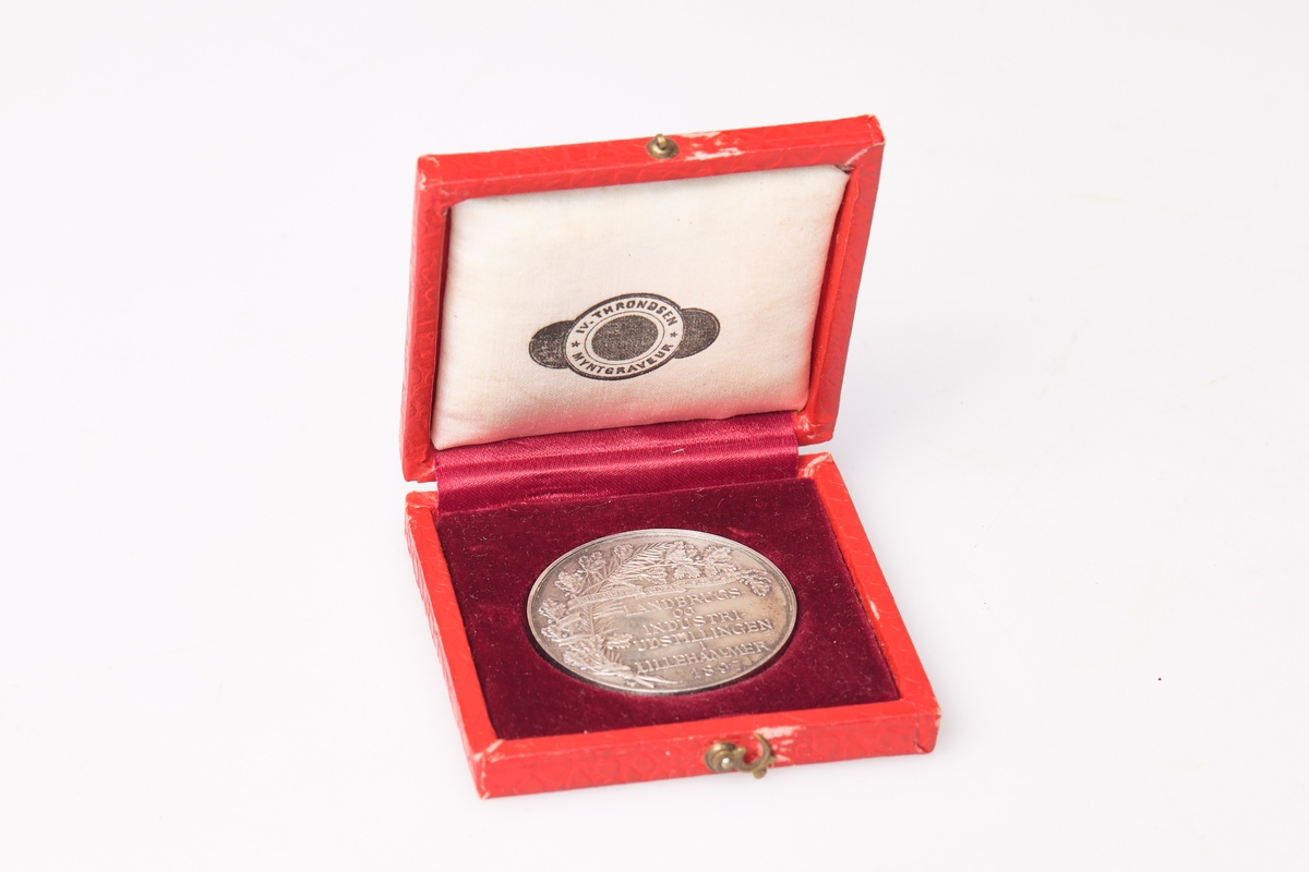 Medalje og rødt etui. Medaljen er produsert av Throndsen myntgraveur.