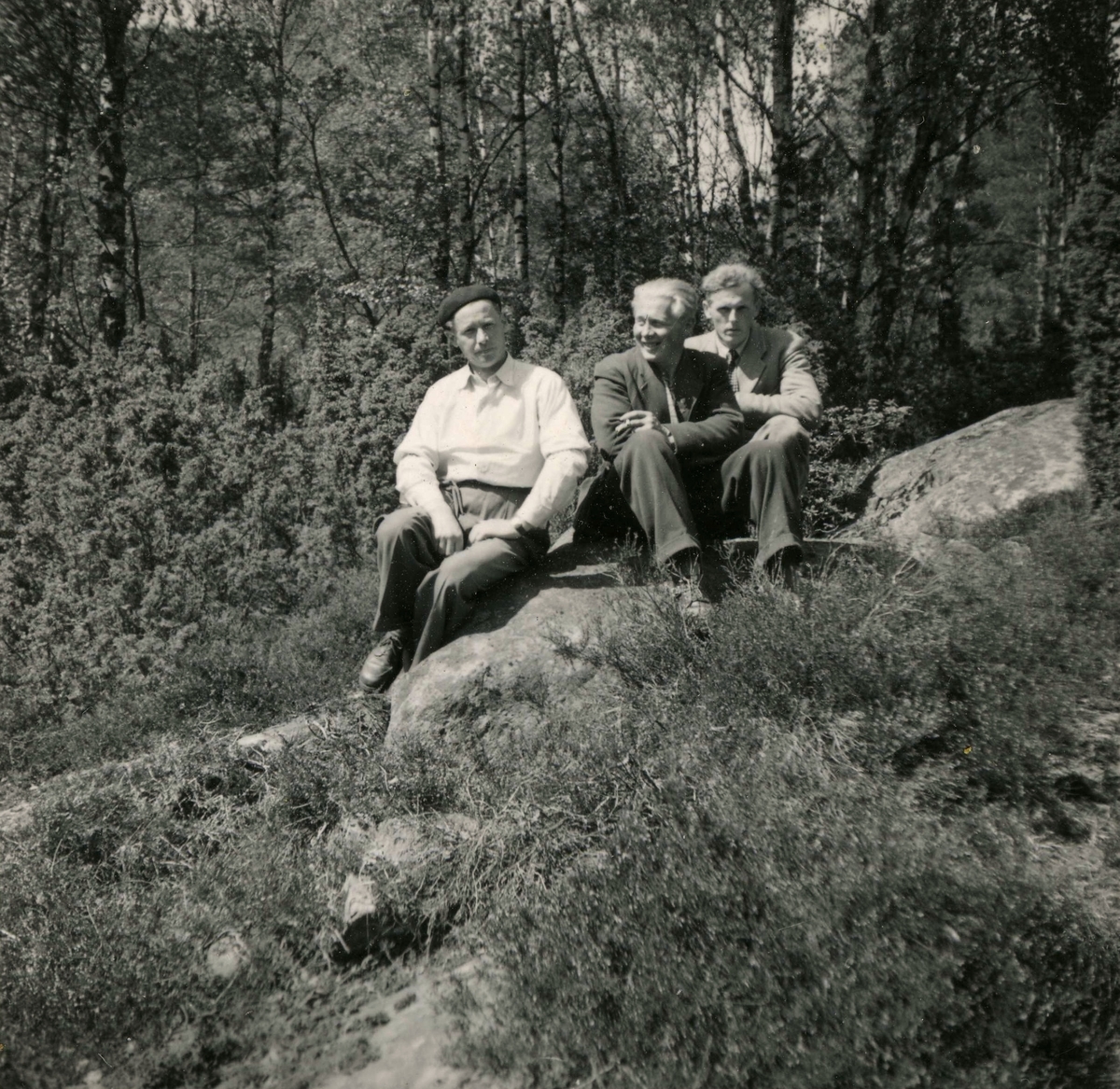 Tre män sitter på en stenbumling vid Ekans gård, Ekan 1:1 år 1953. 
Från vänster: 1. (i basker) Rolf Svensson (1909 - 1989), Ekan. 2. Einar Lindkvist (1922 - 2002) som arbetade på gården. 3. Sven Erik Stenbom (1926 - 2003), Tollered (granngård till Ekan).