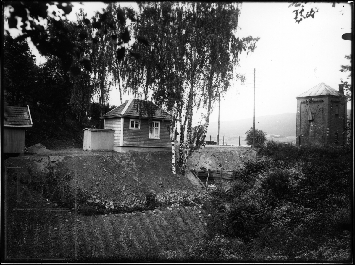Et lite hus eller bu. Sett fra to forskjellige vinkler. Vanntårn for jernbane på det ene bildet.