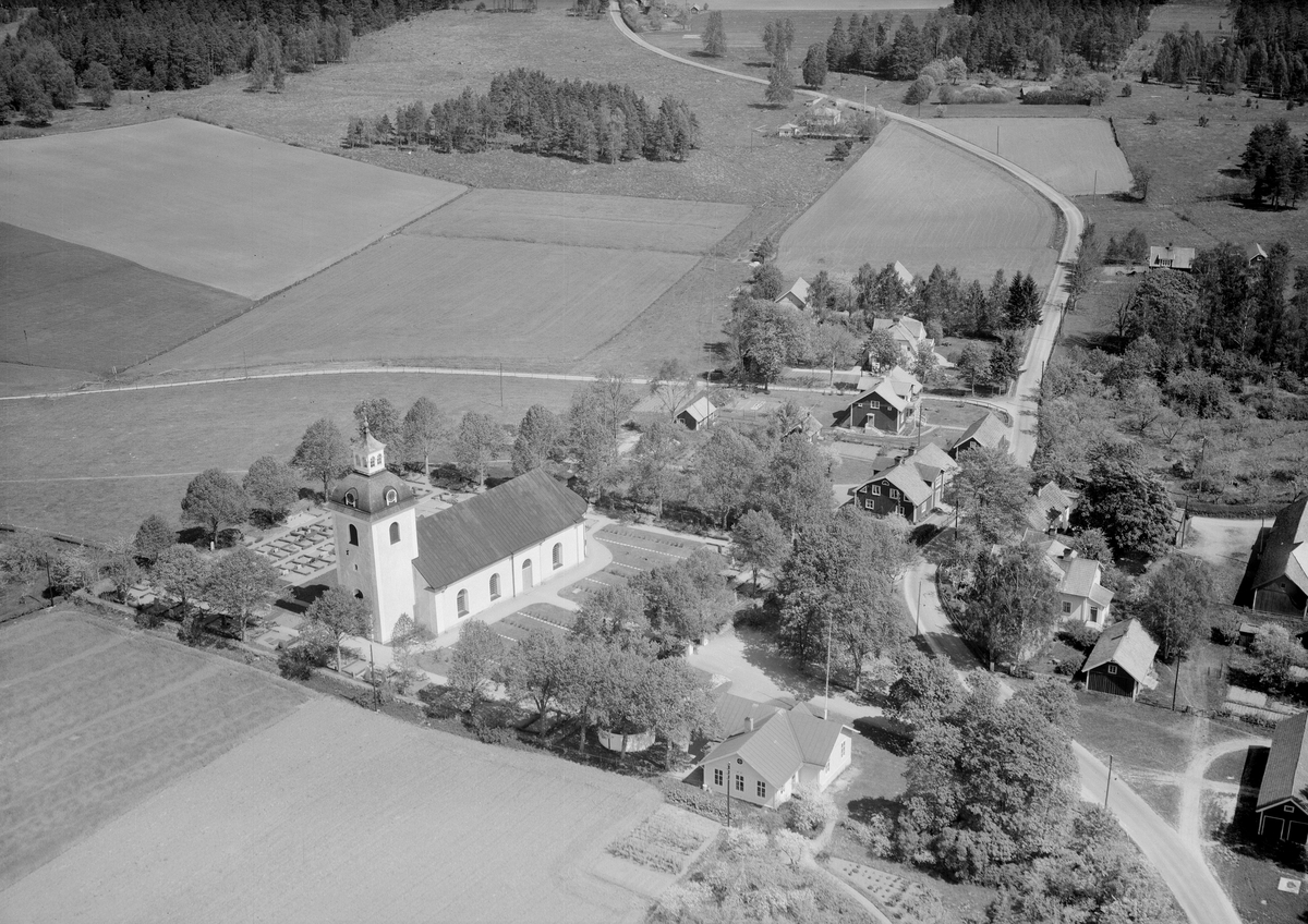 Flygfoto över Rappestad kyrka med omgivning. Församlingens nuvarande kyrka fullbordades 1802 och är i sin solida enkelhet en typisk representant för tiden. Bland byggnaderna till höger i bild ses kyrkskolan och ortens kommunalhus.