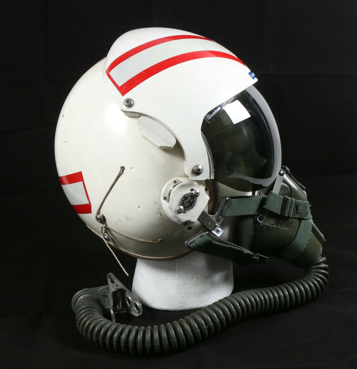 Flygerhjelm malt hvit med refleks som ligger på toppen av en rød stripe som går over toppen på hjelmen