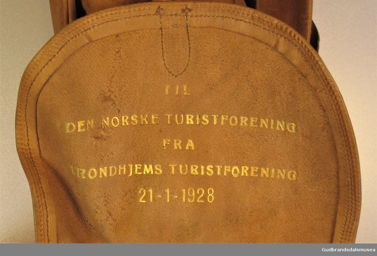 Adresse til DNT fra Trondhjems Turistforening i anledning av 60-års jubileet i 1928. Adressen er oppbevart i  LÆRHYLSE utformet som en lien ryggsekk med lokk og ryggreimer.