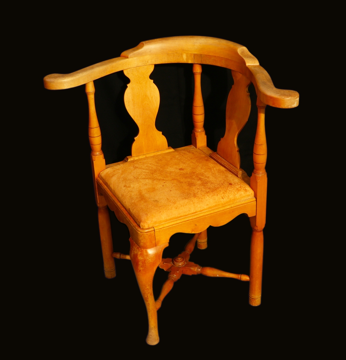 Puderstol förmodligen i björk. Fyrkantig sits som är vänd så att ett hörn är vänt framåt. Ryggstödet är vinkelgående på två sidor med svarvade ryggstolpar och mittståndare och balusterformade ryggbrickor. Främre benet är svängt medan de andra är raka, svarvade krysslåar förbinder benen. Profilerad sarg. Sitsen är löstagbar och stoppad, klädd i skinn. På undersidan ett blått tyg där tygerna är nitade.
