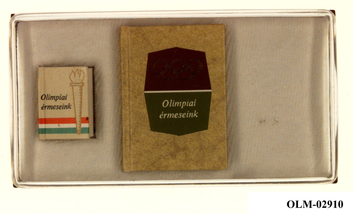 To forskjellige miniatyrbøker i ett etui, på den ene er flagget til Tadsjikistan. Den ene boken har bilde av en fakkel med flamme, den andre boken de olympiske ringer.