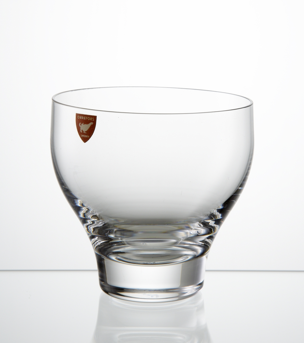 Design: Ingeborg Lundin.
Barglas med klotformad kupa med indrag mot botten. Fabriksmärke: röd botten med vit text.