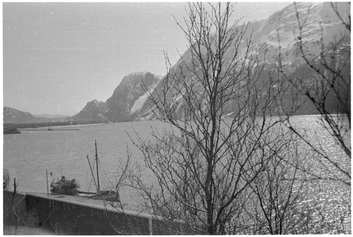 Utsikt fra kaiområdet i Mosjøen og innover mot byen. En båt ligger ved kaia i forgrunnen.
