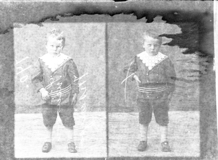 Två porträtt av en liten pojke på en glasplåt. Han håller handen i sitt bälte.