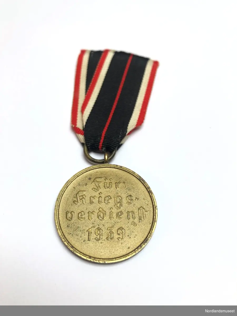 Forsiden av medaljen har et malteserkors med hakekorset i midten, og på baksiden står det stemplet «Für krigsverdienst 1939» (For krigsfortjeneste 1939).