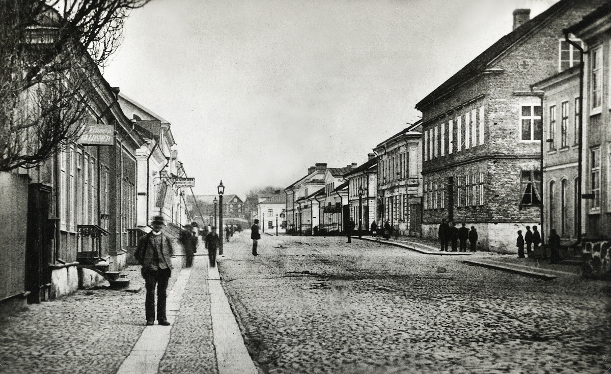 Storgatan Växjö, österut, ca 1880. Till vänster ser man husen i kvarteren Nunnan och Klostret, till höger några av husen i kvarteren Stormen, Blenda och Unaman. I fjärran ser man gårdsbebyggelsen vid Östregård.