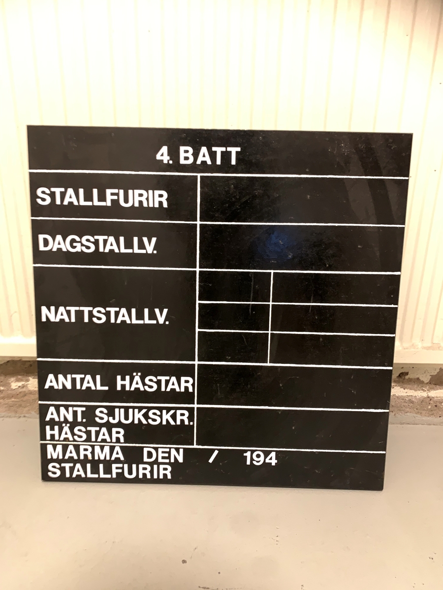 Stalltavla för "4 Batt" 
Av trä
Vit text på svart botten