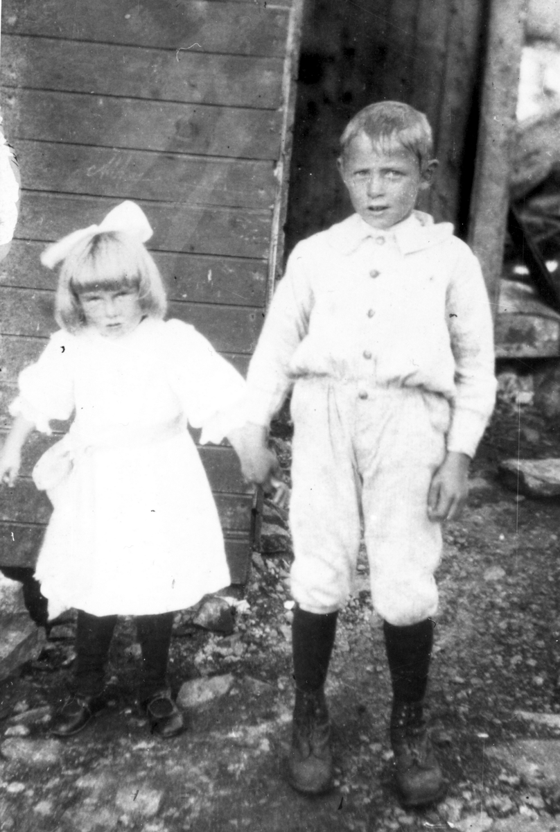 Martha Heitmann, f.1915 Skaland, (senere gift med Arvid Lund), Signar Heitmann, f.1912 Skaland, senere gift i Bardu. De står foran huset "Strand" på Skaland i ca 1920.