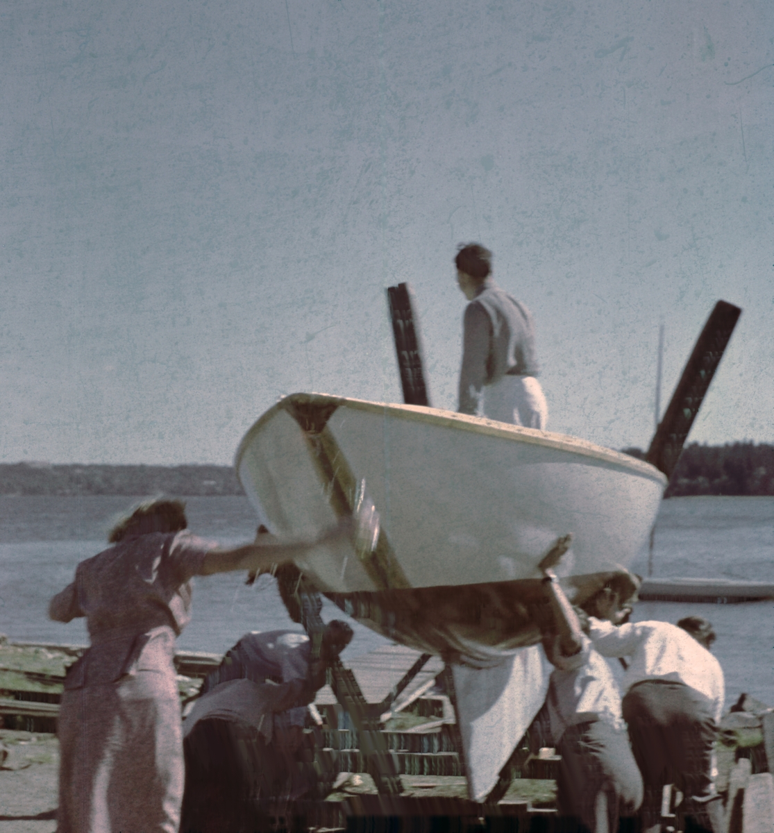 Första sjösättningen av segelbåten DECIBEL vid Skärsätra båtklubb, Lidingö. I båten ägaren Holger Marcus, längst t v troligen hustrun Aina.