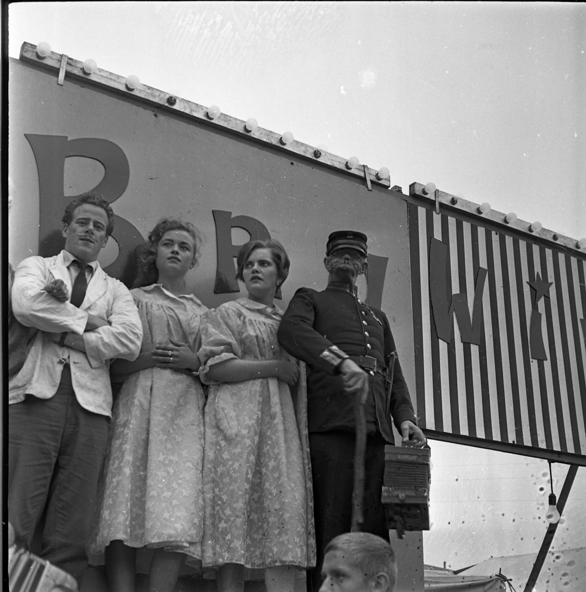Ett scenuppträdande i samband med Gränna marknad. Två kvinnor och två män står arm i arm på ett podie. En av männen håller ett dragspel i handen.