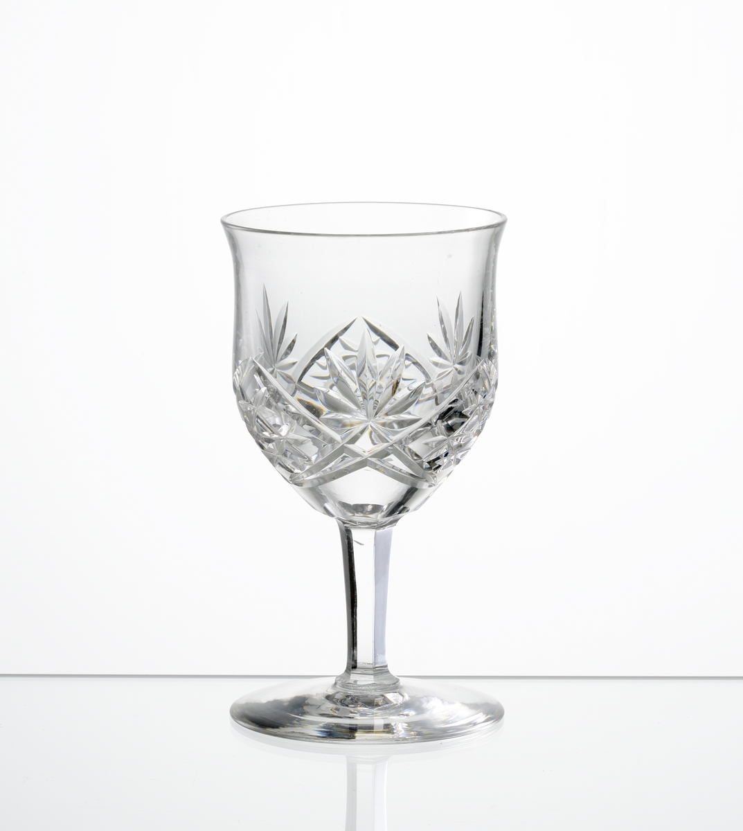 Design: Okänd. 
Sherryglas, lätt klockformad kupa med skärslipad dekor. Lågt fasettslipat ben med slät fot.
