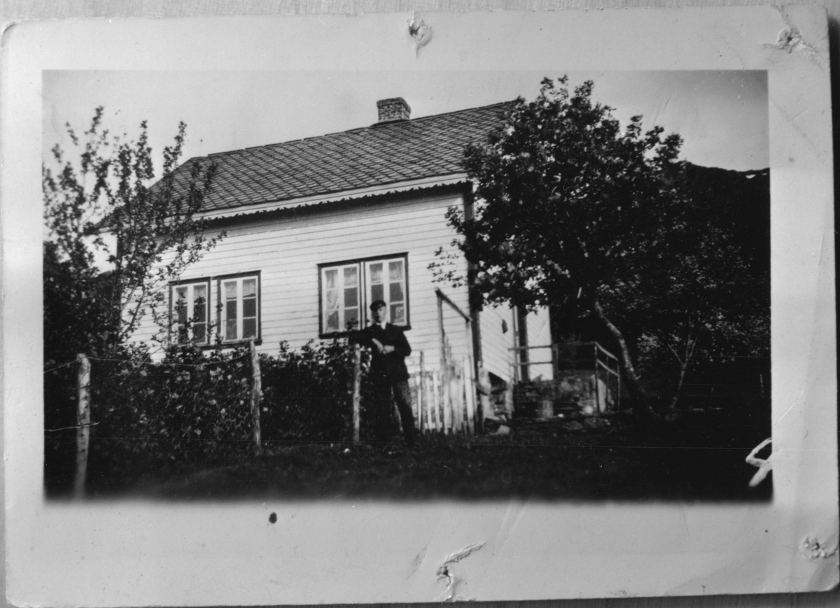 Huset til Gjertrud Flatebø på Haugsgjerdet i Bjoa, ca. 1940. Ståande foran huset er Ole A. Tvedt.