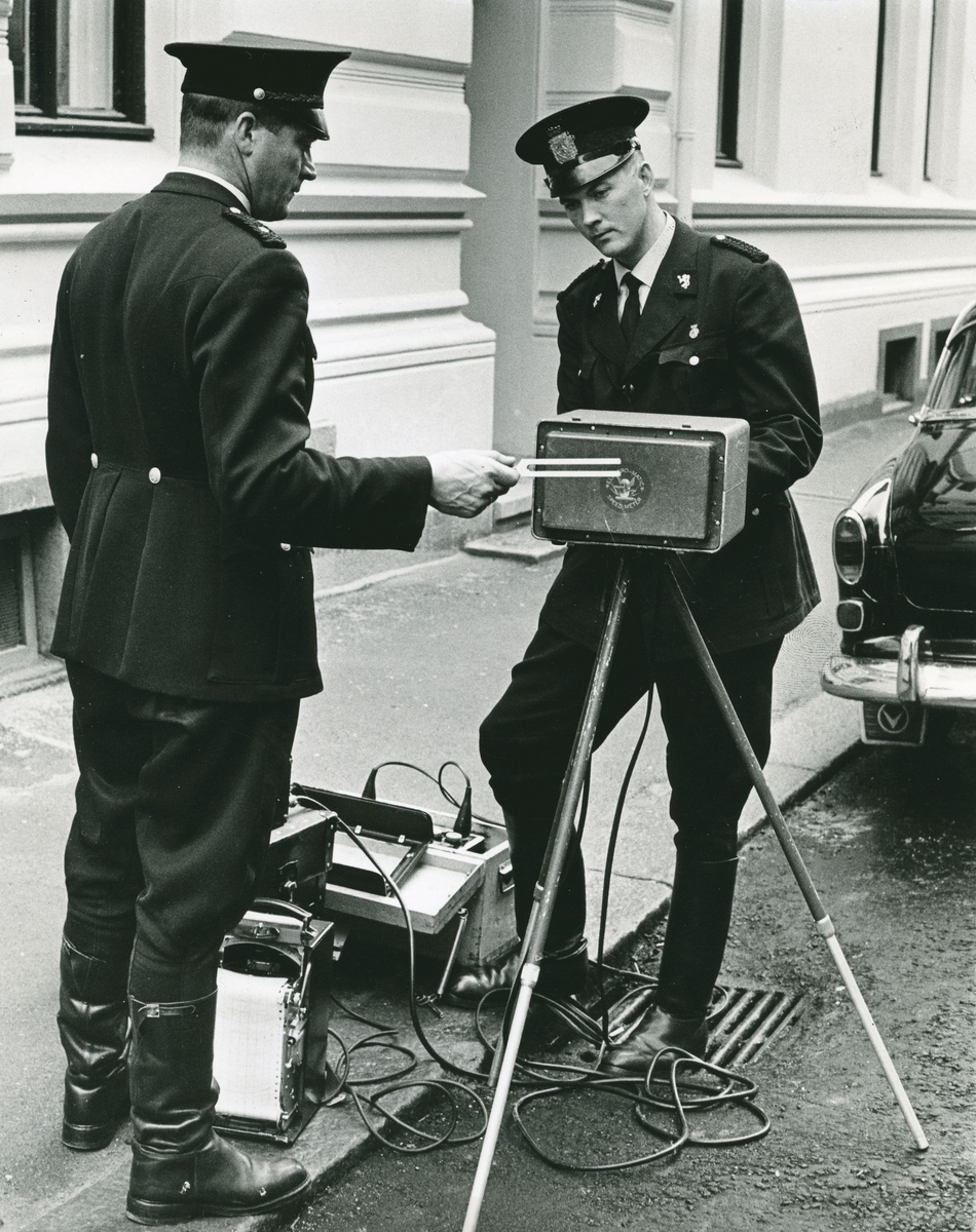 To politimenn kalibrerer en radar ved hjelp av stemmegaffel.