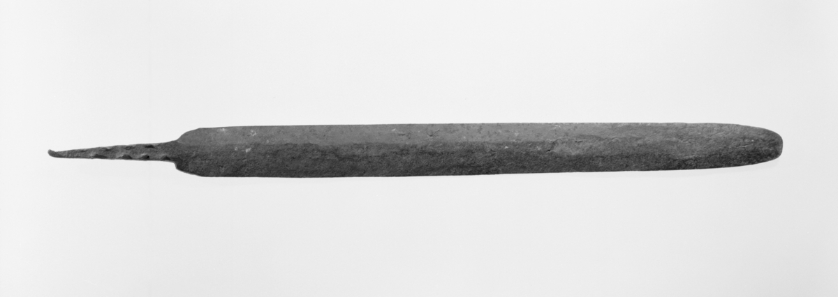 Vevsverd av jern, med avrundet odd og lett markert rygg på en flatside. Forarbeidet tange for grepet. Trolig yngre jernalder/middelalder. L. 63 cm, tange 10,5 cm, bladtykkelse 0,8 cm, greptykkelse 1,5 cm, st. br. 4,5 cm. Funnet 1972 i en steinrøys som skal stamme fra bygning i gamletunet på Hafskor, gnr. 18, bnr. 5, Fusa, Hordaland. Gave fra G. Havsgård