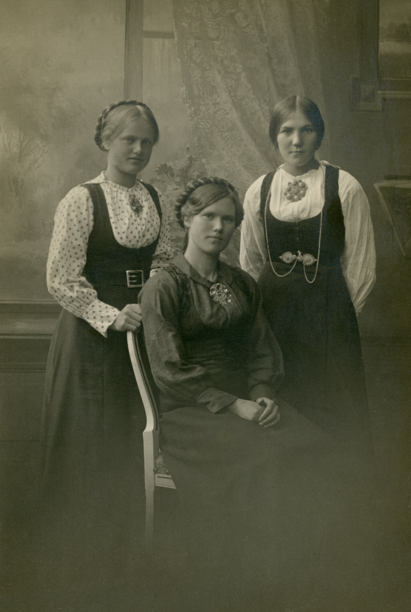 Tre unge kvinner i fotoatelier.  F. v Anne Pladsen Dalen, Mari Pladsen Sanda og Mari Bakås eller Brukås