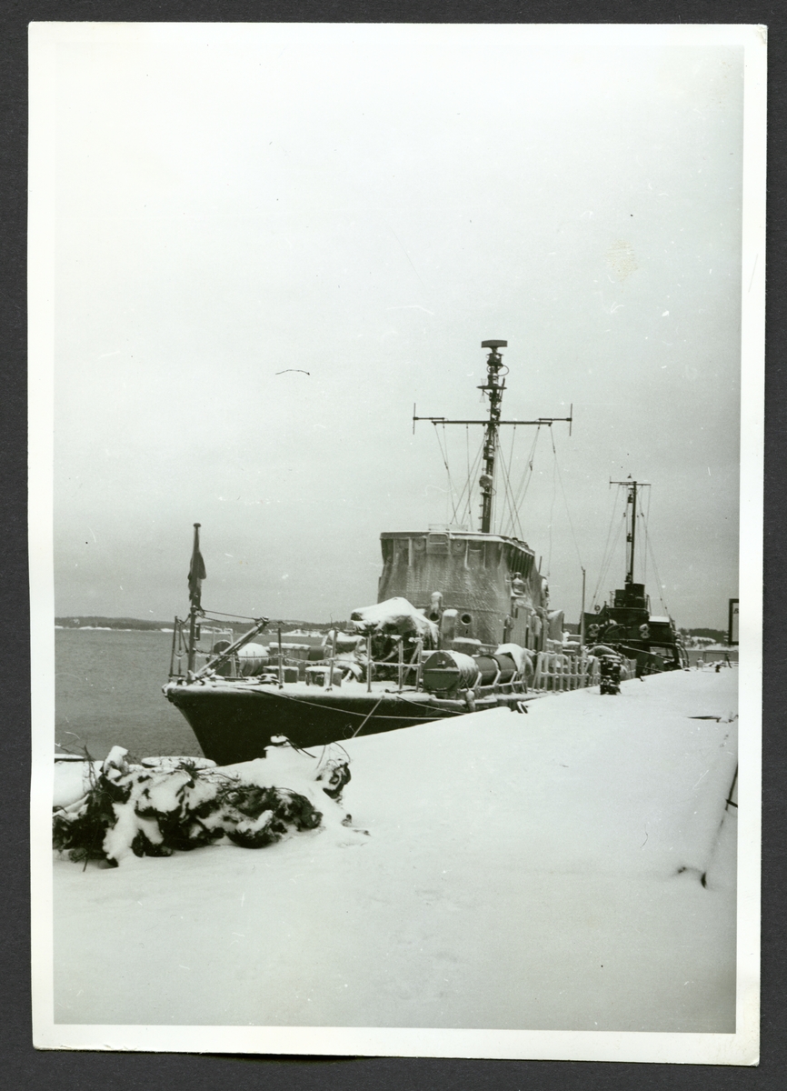 Bilden visar torpedbåten Perseus förtöjt vid kajen under vintertid.