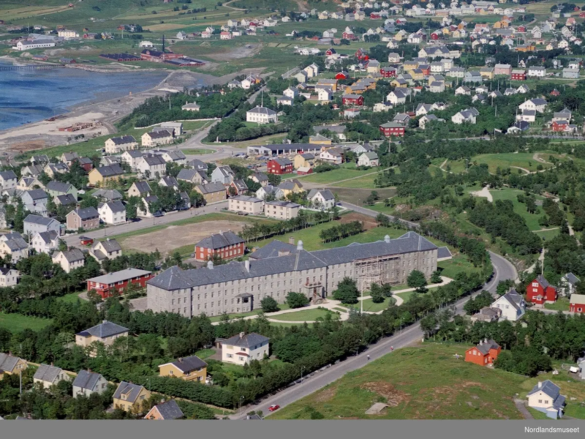 Widerøes flyfoto - skråfoto, farge - over Bodø med daværende Bodø Sykehus (nå: Nordland Sentralsykehus) i retning mot Rønvik. Vi ser Parkveien i forgrunnen.