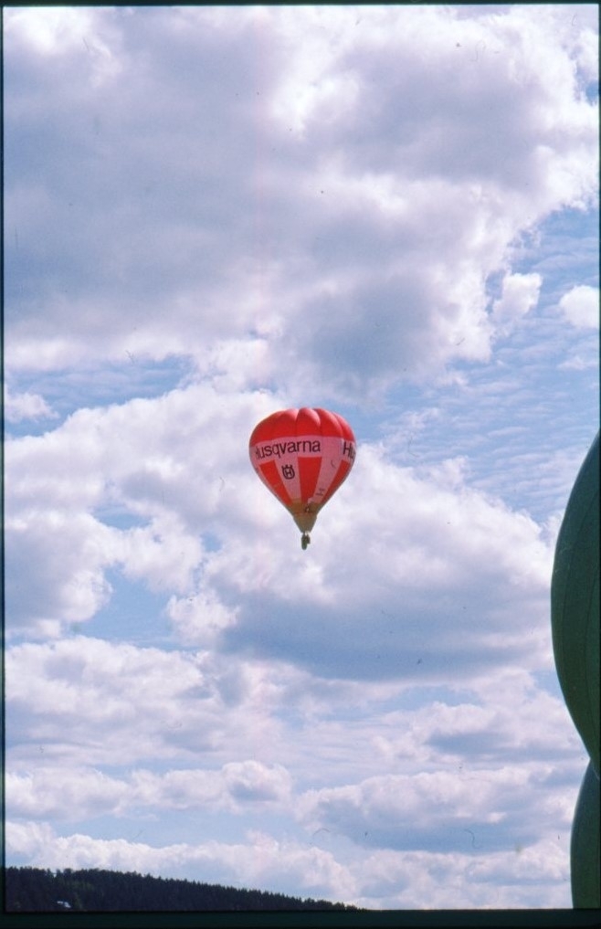 En rödvit ballong märkt "Husqvarna SE-ZZV" samt "Örnen II Gränna" i luften ovan Gränna.