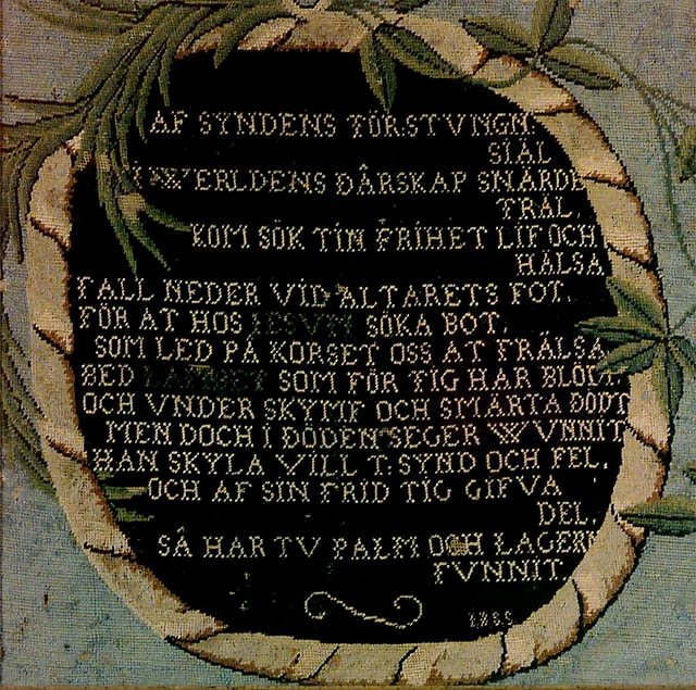 Mittpartiet på ett antipendium, broderat i ylle på stramalj. Daterat 1694. Inom glas och ram. Har tillhört Örsjö? Kyrka.