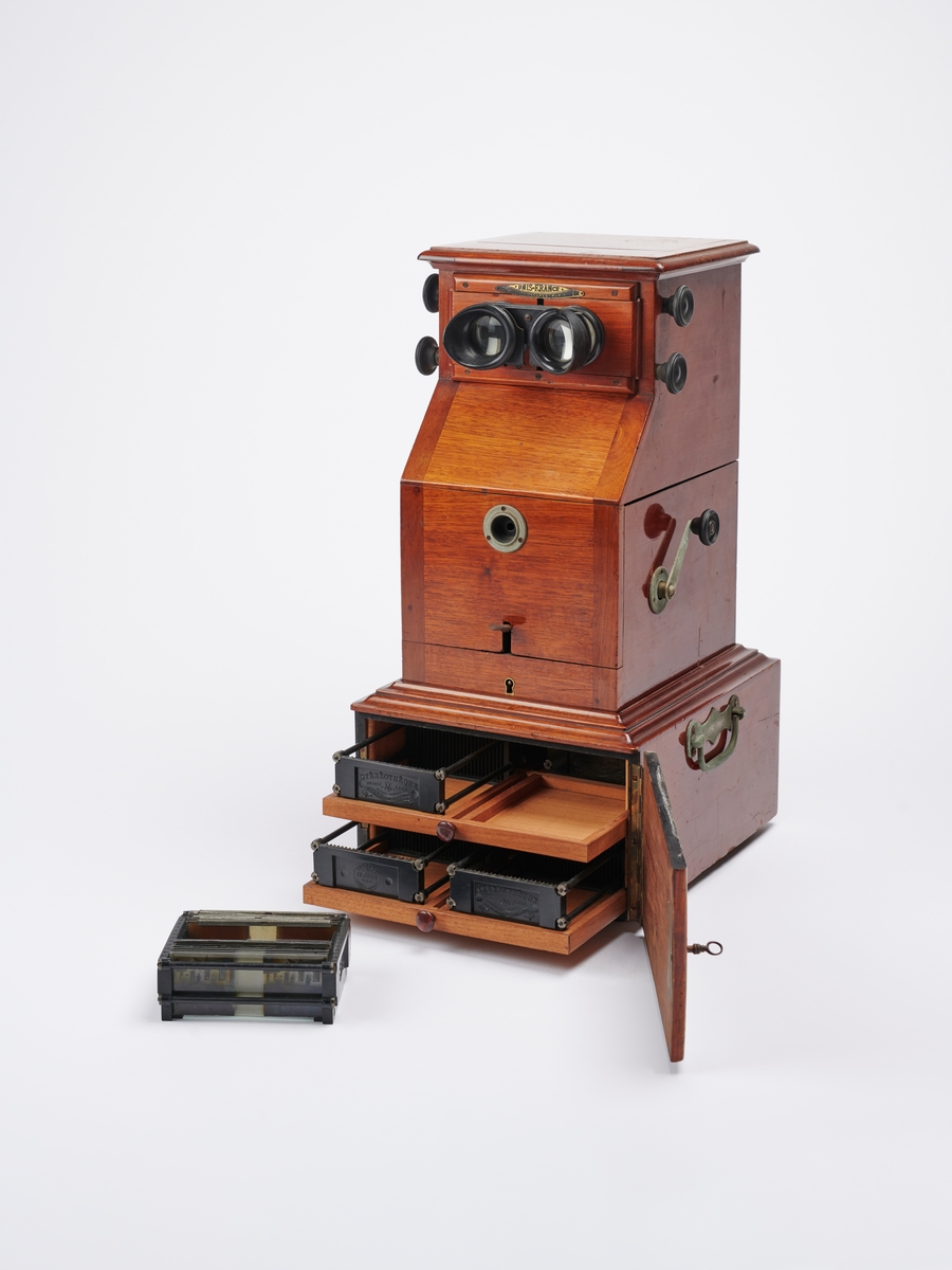 Bordstereoskop produsert av det franske firmaet Mattey. Stereoskopet har oppbevaring til stereofotografier i egen skuff. 
Stereokameraene ga en svært populær form for bilder på slutten av 1800-tallet. Stereofotografi var med på å forme fotoindustrien. Folk ønsket å se mer av verden, og stereofotografiet gjorde det mulig å forestille seg at man var til stede i motivet, grunnet en optisk effekt som utnytter dybdesynet vårt.  
Et stereokamera har to objektiver med en avstand på litt over seks centimeter, omtrent samme avstand vi har mellom pupillene. En eksponering gir dermed to bilder av samme motiv. Når dette paret med fotografier blir montert, f.eks. på en papplate, og sett på gjennom en stereobetrakter, fremstår motivet som tredimensjonalt.