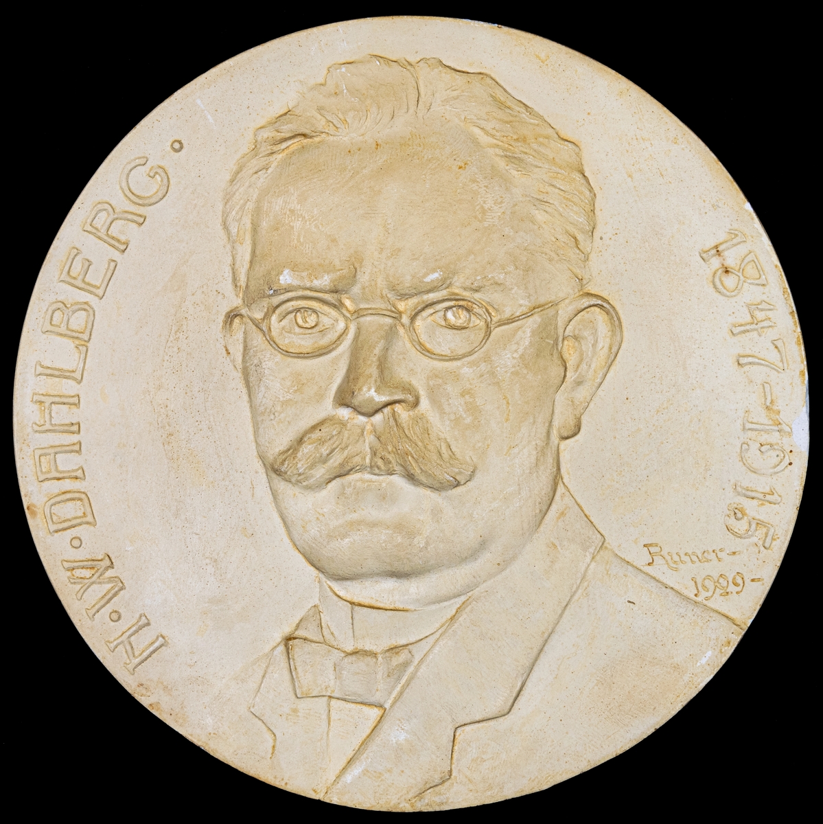 Porträttrelief föreställande N.W. Dahlberg (1847-1945).
Sign. John Runer 1929
