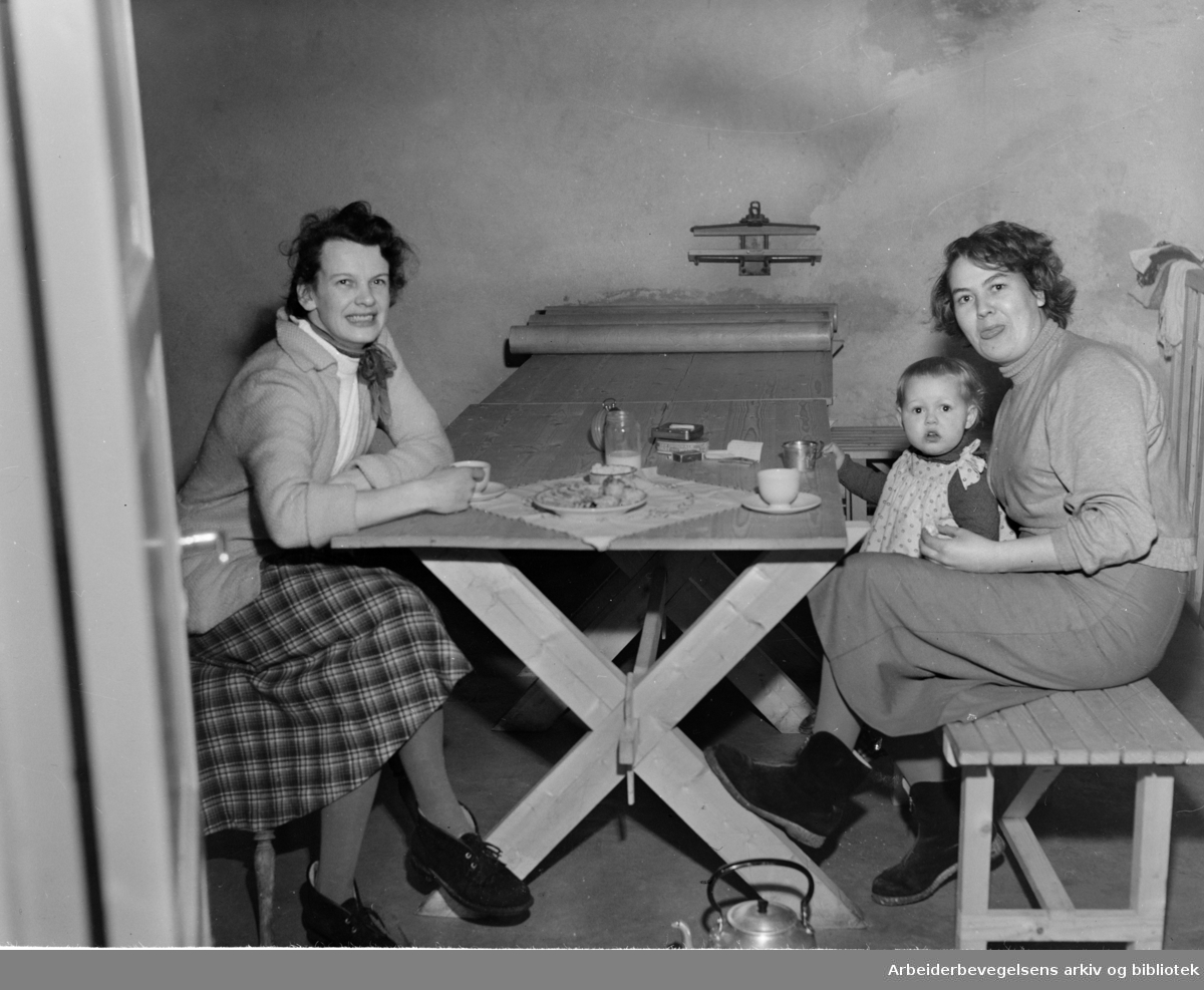 Sigrid Kristiansen, lille Bente og Eva Pedersen i en vaskejeller i en av stjerneblokkene på Grorud. Februar 1954