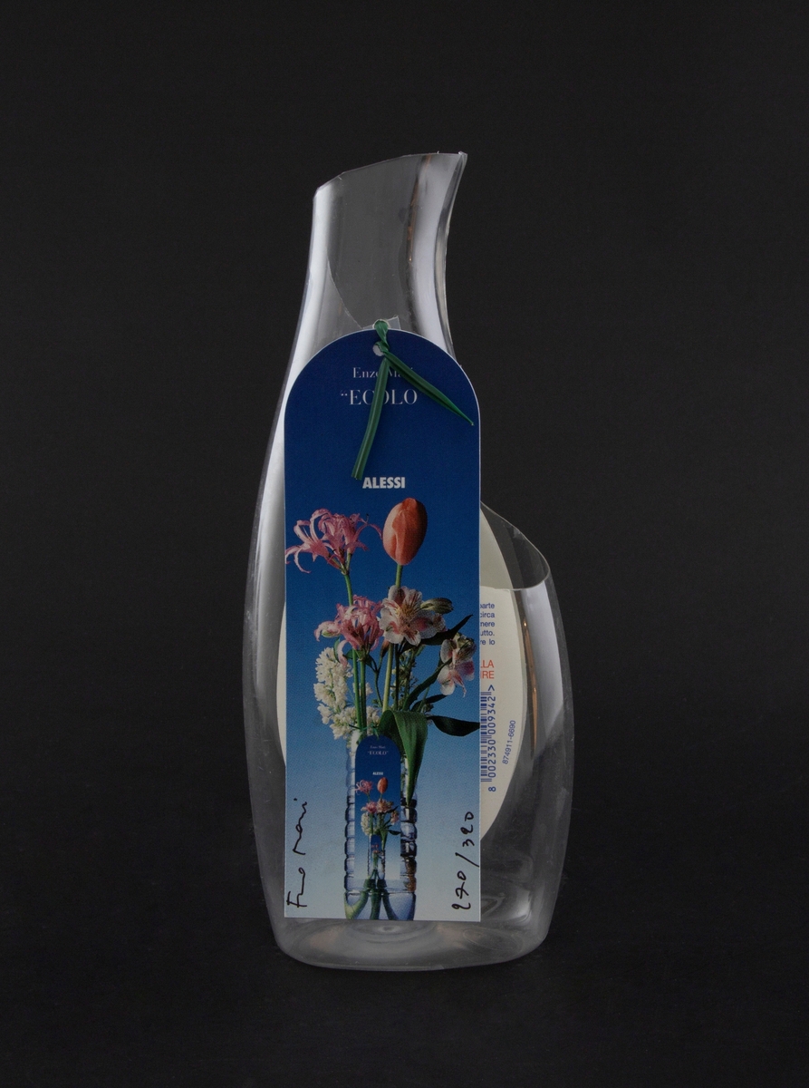 Vase laget av plastflaske for rengjøringsmiddel. Kort med bilde av blomster i vase er festet til vasen med et grønt feste.