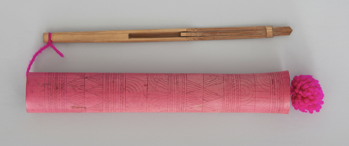 Munnharpe skåret av ett stykke bambus. Snerpen løper helt parallelt med rammen som er rett og smal.
Harpen festet med en lilla bomullsnor til et etui av bambus-rør lukket i den ene enden. Etuiet er beiset lilla og dekorert med innrisset strekdekor.