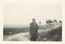 Kvinne i front iført turklær i fjellet. Bak sees forsamling 