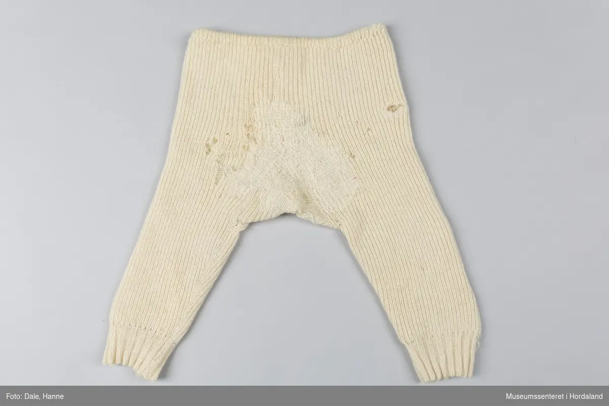 Strikka underbukse med bråt på bein, strikk i livet, sydd saman. Buksa har fleire hol og er stoppa mange gongar på beina og i skrittet.