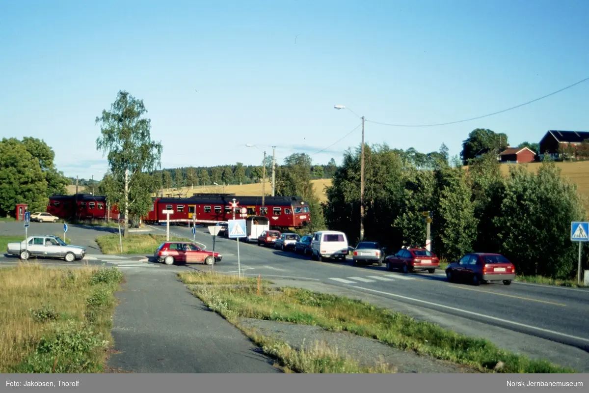 Lokaltog til Moss, tog 129, med motorvognsett type 69 passerer planovergangen på Holstad stasjon på Østfoldbanen