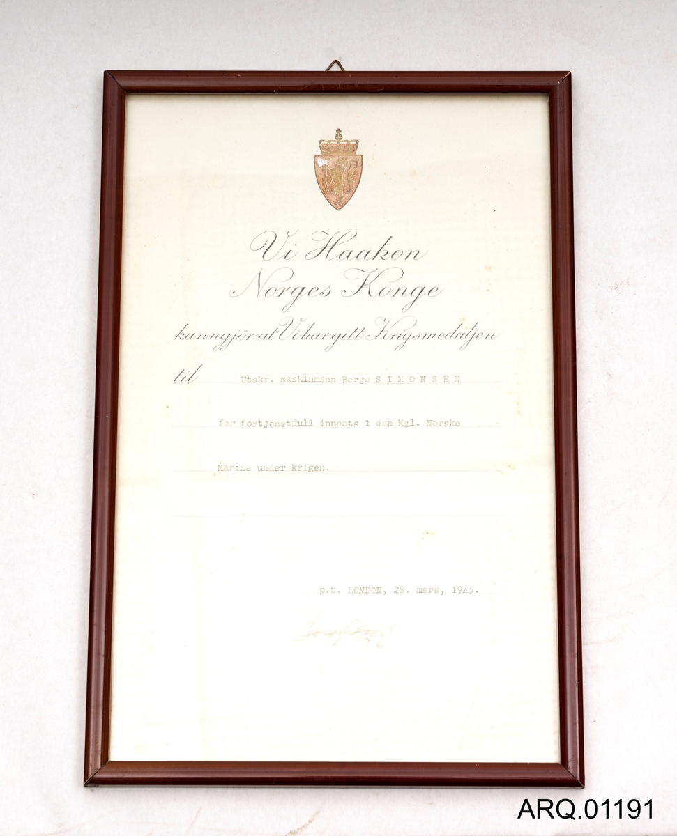 Et sertifikat i ramme til; Utskr. Maskinmann Berge Simonsen Vik for fortjenstfull innsats i den Kgl Norske Marine under krigen. Signert i London, 28. mars 1945. Innrammet på profosjonell måte.