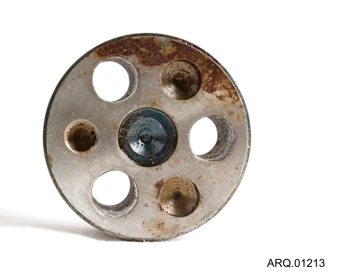 Et forholdsvist kort sylinderformet verktøy med 3 stk huller som gå gjennom sylinderen. Ellers er den tett, men har 4 stk groper på overflaten (oppsiden). Mulig maskindel
