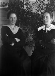 Portrett av to kvinner i stua på Fjellstad gård.