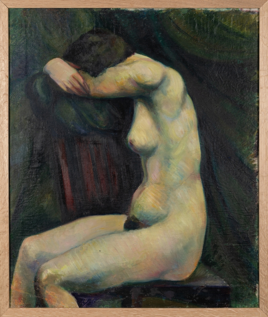 Kvinne sit på stol med hovudet gøymd i ein svart tekstil på toppen av stolryggen. Skildra frå øvst på leggen og opp.