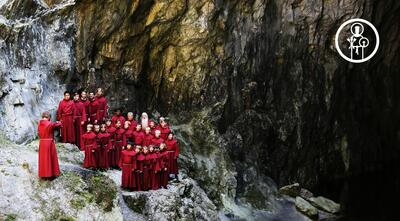 St. Hallvard-guttene i røde korkapper står og synger i en fjellformasjon.. Foto/Photo