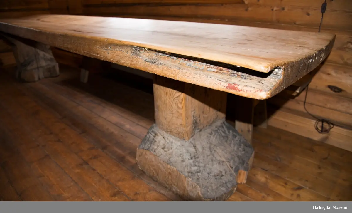 Lanbord som er lagd av en stor planke.  Det hviler på 2 store stabber. I ene bordeneden er det slått inn 4 hvite melketenner og 2 grå steiner eller melketenner (usikker).