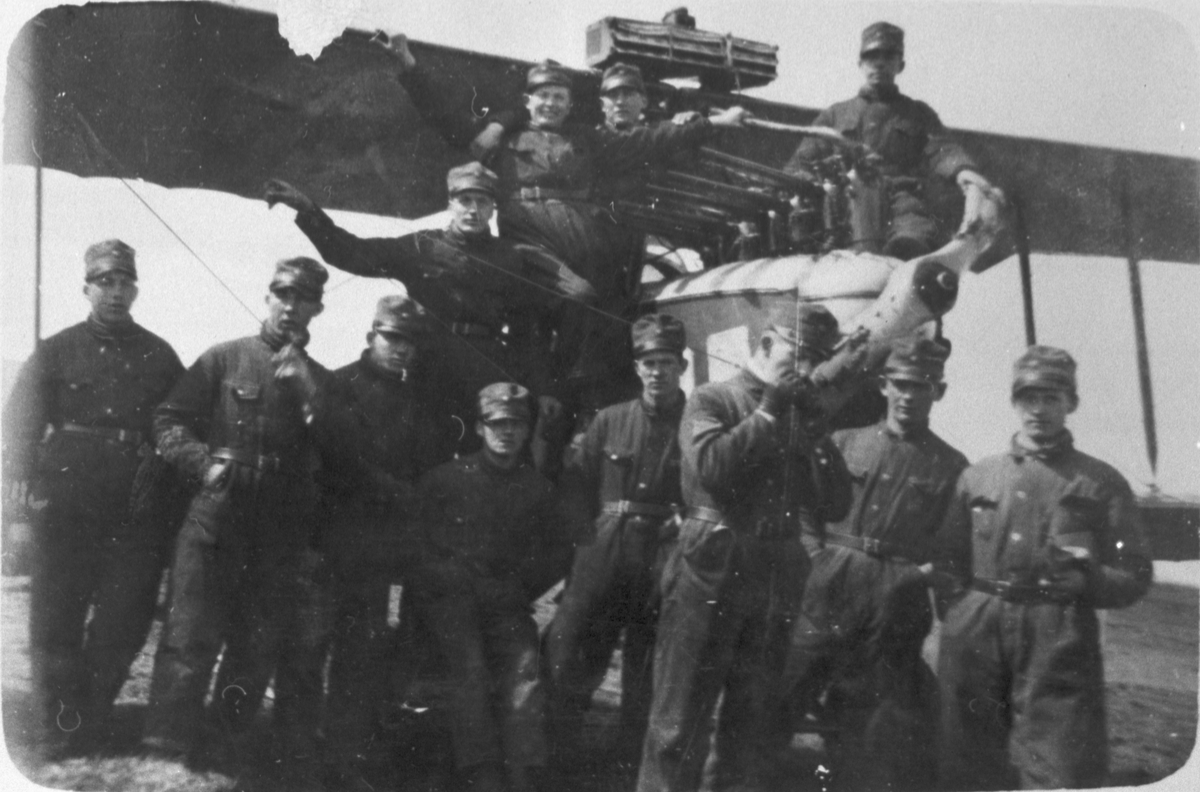 Grupporträtt av tolv militära flygmekaniker framför flygplan Albatros, ca 1918-1929.