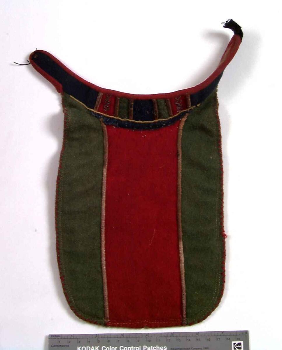 Flerfarget brystklede med biser i skinn, tinntråd og tekstilapplikasjoner. Hoveddel er med vertikale stykker i grønt ytterst og rødt i midten.