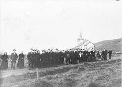 Begravelsesfølge med hest og vogn. Kvæfjord kirke i bakgrunn
