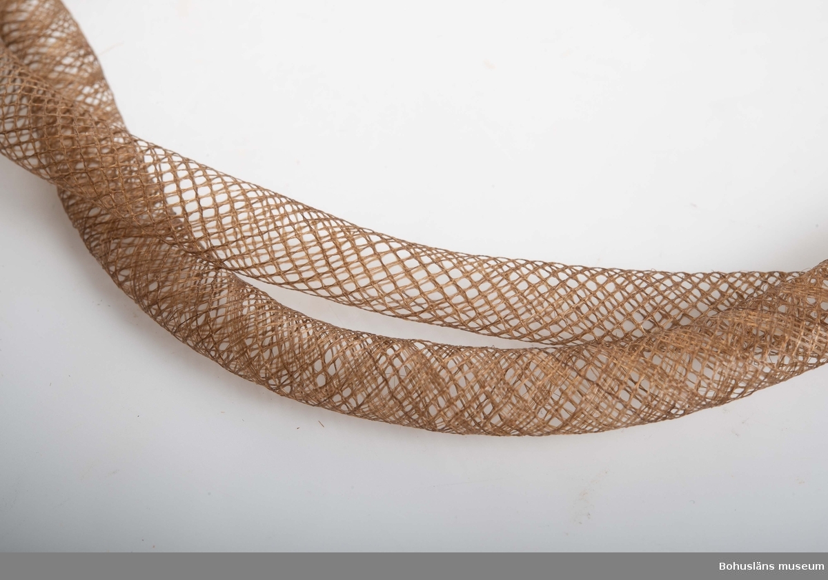 Halsband tillverkat av människohåri dubbla rader, (länkar).
Se även UM018732.