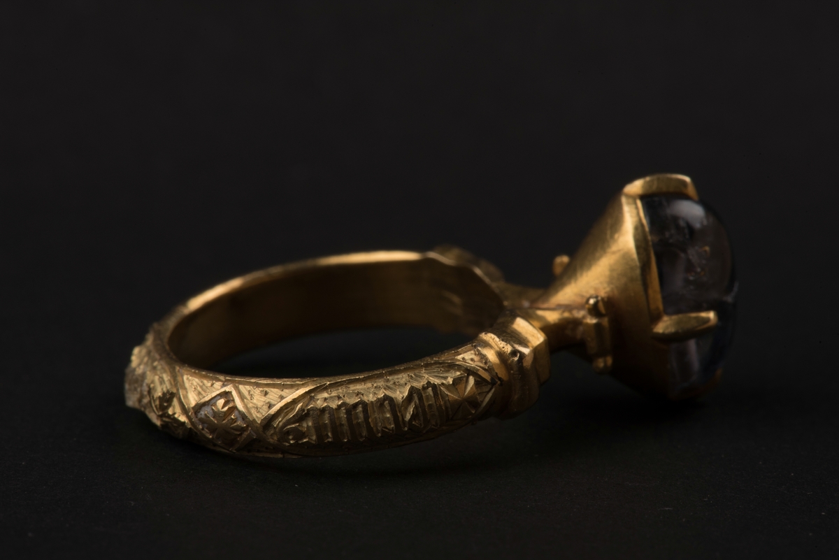 Ring av guld med oval safir.
Safiren vilar i konisk fattning med fyra gripklor. Ursprungligen var troligen ringen belagd med emalj. Ringens utsida har bokstavsfält med betydelsen "safiren vakar över Eder".